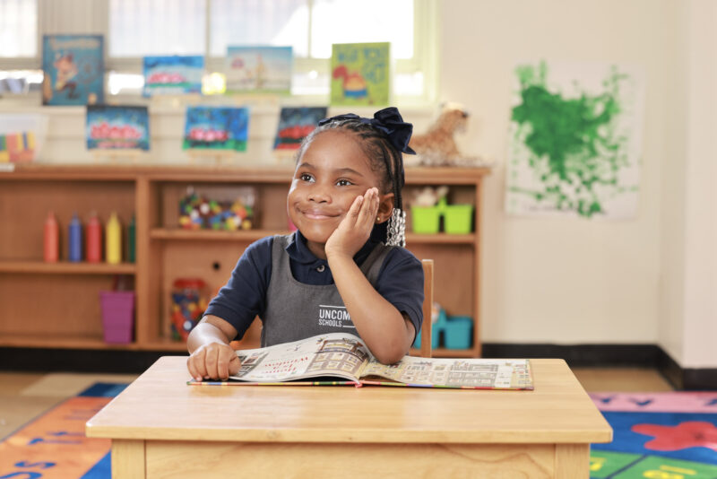 Young student sitting at desk staring off wistfully